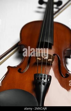 Schöne Geige und Schleife auf grauem Tisch, Nahaufnahme Stockfoto