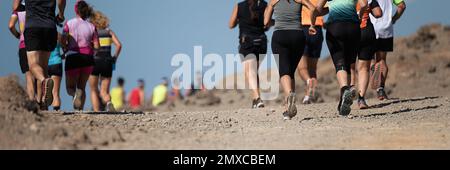 Laufschuhe für Läufer beim Traillauf. Die Beine von Ultra-Running-Athleten nähern sich dem Laufen auf dem Rock Path Trail Stockfoto