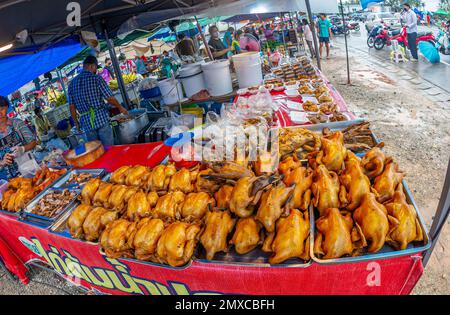 24. Januar 2023- Chumphon Thailand- überfüllter Markt, der Hühnchen-Verkäufer mit einer Maske hinter dem Stand verkauft. Stockfoto