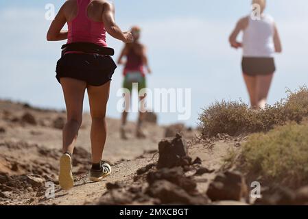 Laufschuhe für Läufer beim Traillauf. Die Beine von Ultra-Running-Athleten nähern sich dem Laufen auf dem Rock Path Trail Stockfoto