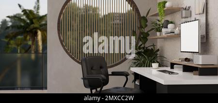 Seitenansicht des modernen, zeitgenössischen Innendesigns des Arbeitszimmers mit Computermodell und Zubehör auf einem modernen Tisch, Sessel, Zimmerpflanze, rundem w Stockfoto