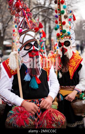 Maskierte Kukeri-Tänzer in farbenfrohen Outfits aus der Region Zentralbulgaren beim Surva International Masquerade and Mummers Festival in Pernik, Bulgarien, EU Stockfoto