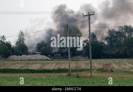 Rauch steigt von einem schweren Brand auf einem kleinen Industriegebiet in Suffolk Ackerland Stockfoto