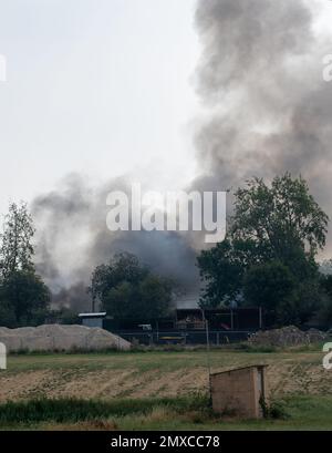 Rauch steigt von einem schweren Brand auf einem kleinen Industriegebiet in Suffolk Ackerland Stockfoto