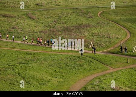 Ein Blick aus der Ferne auf Läufer bei einem Laufrennen (The Benfleet 15) im Hadleigh Country Park, Hadleigh, Essex. Stockfoto