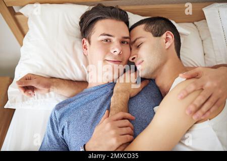 Ist es Zeit, aufzustehen? Porträt eines jungen schwulen Paares, das sich im Bett entspannt. Stockfoto