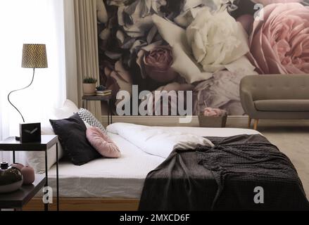 Großes, komfortables Bett im stilvollen Innenraum des Zimmers Stockfoto