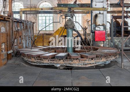 Kattowitz, Schlesien, Polen - Januar 20. 2023: Gießkarussell im Zink-Walzwerk Walcownia Cynku. Schmelzofen und Dampfmaschine im Backgrou Stockfoto