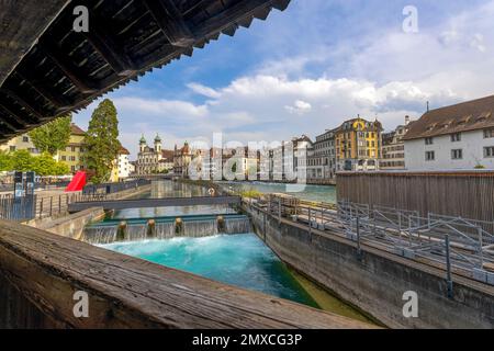 LUZERN, SCHWEIZ, 21. JUNI 2022 - kleine Wasserfälle des Flusses Reuss mit historischen Gebäuden im Hintergrund in Luzern, Schweiz Stockfoto