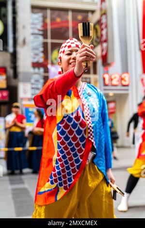 Die junge japanische Tänzerin Yosakoi tanzt und hält Naruko, Capppers, beim Kyusyu Gassai Festival in Kumamoto. Forcus auf dem Naruko. Stockfoto