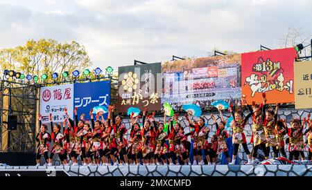 Japanische Kindermannschaft Yosakoi-Tänzer, die Naruko tanzen und Fans auf der Bühne des Kyusyu Gassai Festivals in Kumamoto halten. Stockfoto