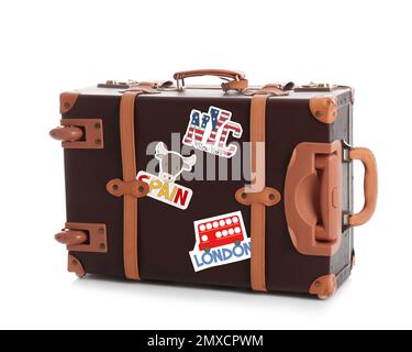 Retro-Koffer mit Reiseaufklebern auf weißem Hintergrund Stockfoto
