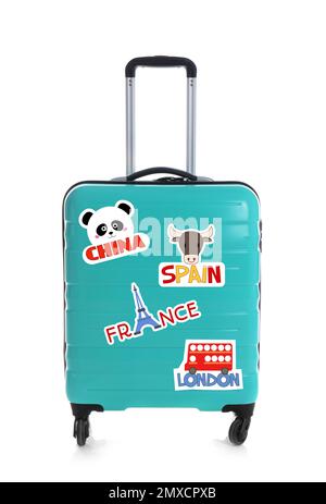 Moderner Koffer mit Reiseaufklebern auf weißem Hintergrund Stockfoto