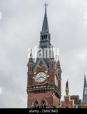 Ein vertikales Bild des Uhrenturms des Bahnhofs St. Pancras vor dem wolkigen Himmel in London, England Stockfoto