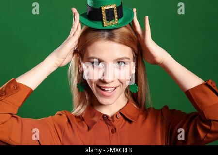 Junge Frau mit Koboldhut auf grünem Hintergrund. St. Patrick's Day-Feier Stockfoto