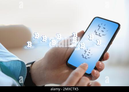 FinTech-Konzept. Schema mit Bitcoin-Symbolen und Mann mit Smartphone Stockfoto
