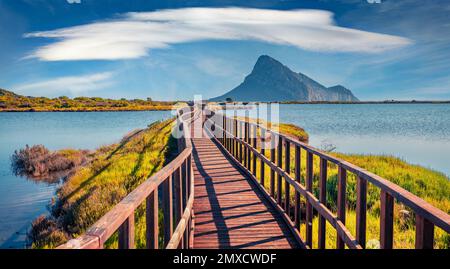 Wunderschöne Sommerlandschaft. Herrlicher Sommerblick auf den Strand Spiaggia di Porto Taverna mit hölzerner Fußgängerbrücke. Wundervolle Morgenszene von Sardinien isla Stockfoto