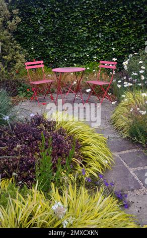 Pink Metal Patio in einer ruhigen gepflasterten Gegend im RHS Garden Harlow Carr, Harrogate, Yorkshire, Großbritannien Stockfoto