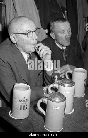 Bier und Zigaretten im Münchner Hofbräuhaus am Platzl, 1957. Bier und Zigaretten im Hofbräuhaus am Münchner Platz 1957. Stockfoto