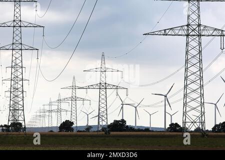 Windturbinen und Strommasten, Österreich Stockfoto