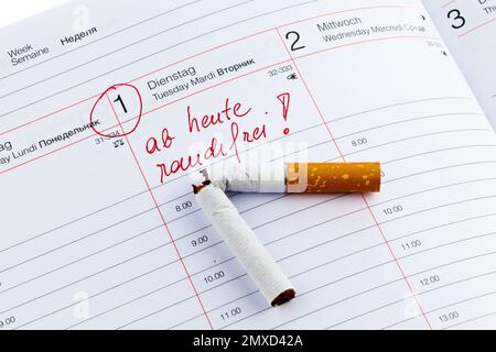 Kaputte Zigarette auf einem Kalender, Absicht, mit dem Rauchen aufzuhören Stockfoto