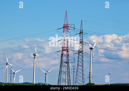 Windturbinen und Strommasten, Österreich Stockfoto
