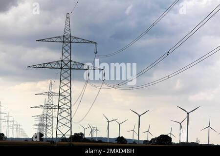 Windturbinen und Strommasten, Österreich Stockfoto