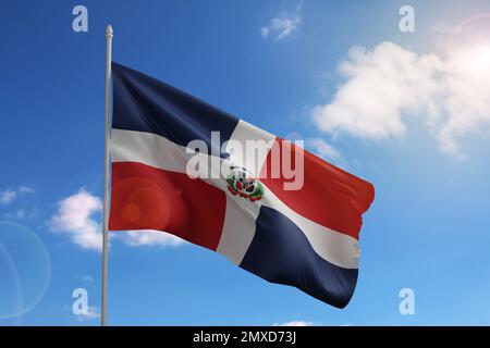 Flagge der Dominikanischen Republik am blauen Himmel. 3D Abbildung. Stockfoto