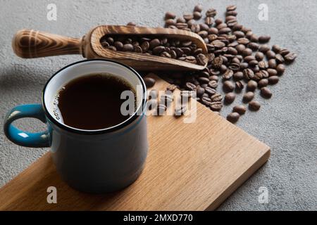 Blaue Tasse Kaffee mit Kaffeebohnen, Blick von oben Stockfoto