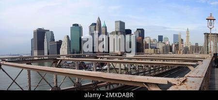 Die glitzernde Skyline von Manhattan von der Brooklyn Bridge – funkelnde Lichter, berühmte Wolkenkratzer und der glitzernde Fluss zeichnen ein pulsierendes Meisterwerk der Stadt aus Stockfoto