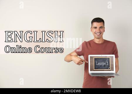 Junger Lehrer mit Laptop auf hellem Hintergrund. Online-Englischkurs Stockfoto