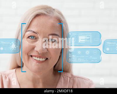 Gesichtserkennungssystem. Reife Frau mit Scannerrahmen im Gesicht und Information Stockfoto