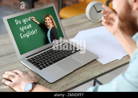 Mann, der mit einem Laptop Englisch lernt, mit einem Lehrer zu Hause, Nahaufnahme Stockfoto