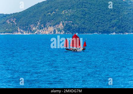 Altes Segelboot mit drei roten Segeln im blauen Mittelmeer vor der Insel Palmaria, Porto Venere, Golf von La Spezia, Ligurien, Italien. Stockfoto