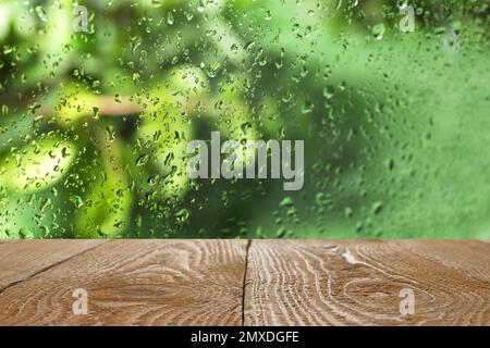 Holztisch in der Nähe des Fensters an Regentagen Stockfoto