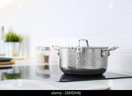Neuer glänzender Kochtopf auf dem Herd in der Küche Stockfoto