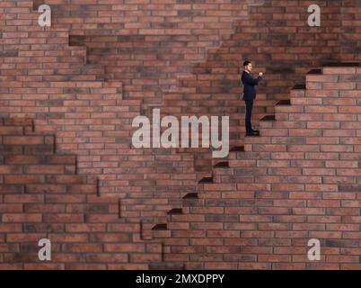 Ein Mann, der auf der Treppe steht und auf die Armbanduhr schaut. Weg zum Erfolg Stockfoto