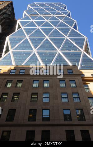 Das berühmte New York City Wolkenkratzer mit einer markanten, diamantbesetzten Glasfassade, umgeben von älteren Gebäuden und einer lebhaften Stadtstraße darunter. Stockfoto