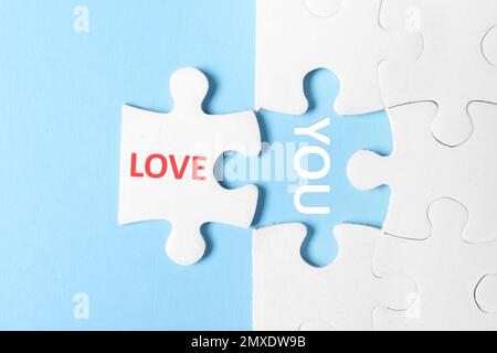 Puzzle mit Phrase LIEBE DICH auf hellblauem Hintergrund, Draufsicht Stockfoto