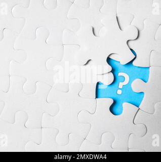 Weißes Puzzle mit fehlendem Teil und Fragezeichen auf weißem Hintergrund, Draufsicht Stockfoto