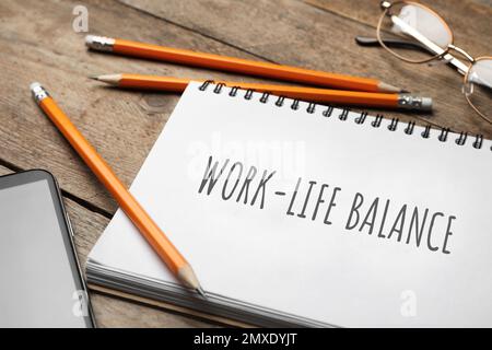 Konzept der Work-Life-Balance. Notebook, Smartphone und Bleistifte auf Holztisch, Nahaufnahme Stockfoto