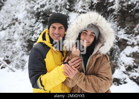 Ein nettes Paar draußen an einem verschneiten Tag. Winterurlaub Stockfoto