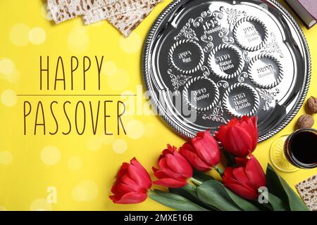 Flache Laienzusammensetzung mit symbolischen Pesach-Elementen (Passover Seder) auf gelbem Hintergrund Stockfoto