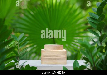 Leere Holzpodium Beton Tischtextur im tropischen Outdoor Naturgarten Wald grüne Pflanze Sonnenlicht Dschungel Hintergrund mit space.organic hea Stockfoto