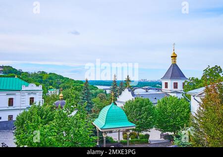 Der Blick über die Dächer und Kuppeln des Klosters Kiew-Pechersk Lavra Cave mit Glockenturm der Kirche St. Anna von rechts und Dnieper River i. Stockfoto