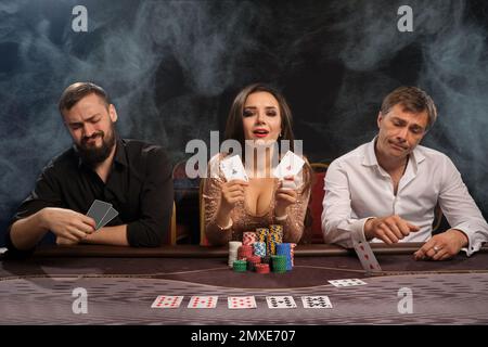 Eine Gruppe junger reicher Freunde spielt Poker im Casino. Stockfoto
