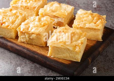 Hausgemachtes süßes Gebäck Galaktoboureko mit Grießcreme auf dem Holzbrett auf dem Tisch. Horizontal Stockfoto