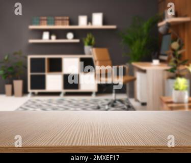 Leere Holzfläche und verschwommener Blick auf moderne Büroeinrichtungen, Nahaufnahme. Platz für Text Stockfoto
