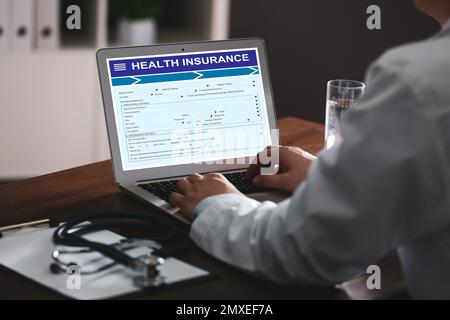 Doktor mit modernem Laptop drinnen, Nahaufnahme. Krankenversicherung Stockfoto