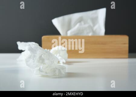 Gebrauchte Papiertücher und Holzhalter auf weißem Tisch Stockfoto